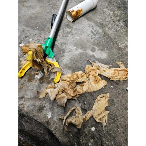 하수구에서 꺼낸 종이타올과 물티슈 같은 이물질이 쌓여 있는 모습, 청소 도구와 함께 바닥에 놓여 있음.동작구하수구막힘